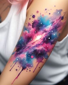 a woman's arm with colorful watercolors on it and stars in the sky