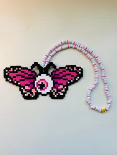 a beaded necklace with a pink and white butterfly on it's back end