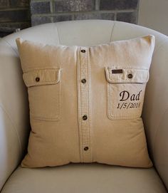 a white chair with a pillow that says dad on it and two buttons in the back