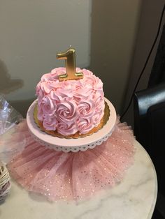 a pink cake with a gold one on top