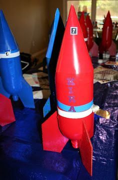 a red rocket ship sitting on top of a blue table