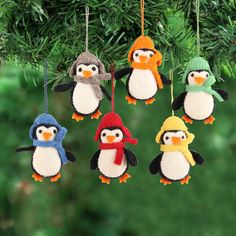 a group of penguin ornaments hanging from a christmas tree