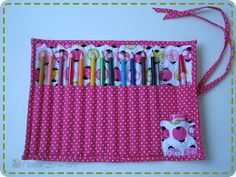 a pink and white polka dot purse with lots of pencils in the pocket on it