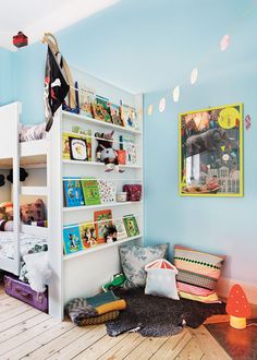 a child's bedroom with bunk beds and bookshelves