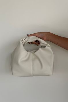 Introducing the Misty Handle Bag: a soft, semi-structured rectangular bag with a wide base, featuring two inner compartments, including a zip pouch. The top opening has a magnetic clasp closure, and the bag is highlighted by a statement wrap handle. Finished with a cotton inner lining, it combines practicality and style! Available in Bone; style with a new Fall outfit! Details: Two Inner Compartments Including with Zip Pouch Top Opening with Magnetic Clasp Closure Statement Wrap Handle Cotton In Mini Hobo Bag, Homecoming Shoes, Red Floral Top, Fall Leather, Gameday Dress, Fall Handbags, Boots Fall, Sweater Sale, Boots And Sneakers