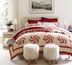 a bed room with a neatly made bed and two stools next to it on the floor