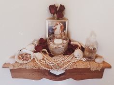 a wooden shelf topped with shells and other items next to a framed photo on the wall