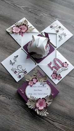 some cards are laying on top of each other and one has a white envelope with pink flowers