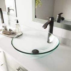 a bathroom sink with a glass bowl and chrome faucet