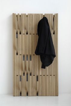 the coat rack is made from bamboo and has two coats hanging on it's sides