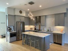 a large kitchen with stainless steel appliances and white counter tops is pictured in this image