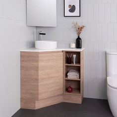 a bathroom with a sink, mirror and toilet in it's corner cabinet next to the toilet