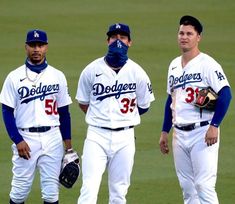 three dodgers baseball players are standing on the field