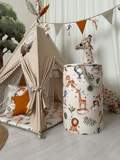 two giraffes are next to a teepee tent and other toys on the floor