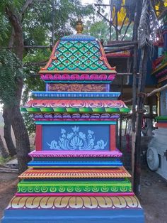 colorfully painted steps on the side of a road in india with trees and buildings behind them