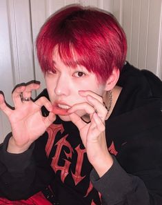 a young man with red hair and piercings on his fingers is posing for the camera