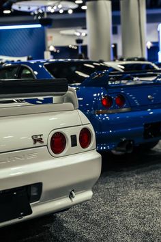 two cars parked next to each other in a showroom