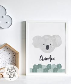 a white shelf with a framed koala print on it next to a clock and other items