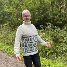 an older man standing in the middle of a road with his hands out and smiling