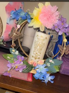 a vase with flowers and butterflies sitting on top of a table next to a mirror