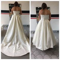 a woman in a wedding dress looking at herself in the mirror and taking her own picture