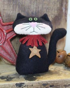 a black cat sitting on top of a wooden shelf next to a star and other decorations