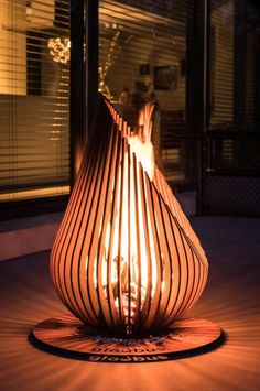 a lit candle sitting on top of a wooden table in front of a window at night