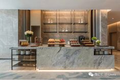 a marble counter top sitting inside of a kitchen next to a bar with drinks on it