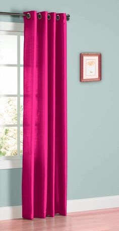 the pink curtain is hanging in front of a window with blue walls and hardwood floors