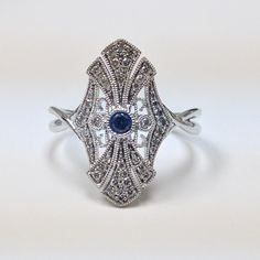 Art Deco Diamond & Blue Sapphire Fashion Ring, Filigree Design 14k White Gold DIAMOND DETAILS: Shape: Round Cut Diamonds Number of Stones: 44 Carats: 0.20 ct. Clarity: VS-SI - Eye Clean Color: H-I GEM STONES: Shape: Round Cut Blue Sapphire Number of stones: 1 Approx. 0.05 ct. Clarity: Eye Clean Color: Medium Blue SETTING: Material: 14k White Gold (Available Also in 14K Yellow Gold or 14K Pink Gold - No Extra Charge) Ring size 7 (custom made in other sizes) Comes packaged In Pop up gift box S Pop Up Gift, Jewelry Images, Filigree Design, Art Deco Diamond, Gem Stones, Fashion Ring, 14k White Gold Ring, Ring Size 7, Round Cut Diamond