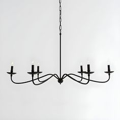 a black chandelier with five candles hanging from it