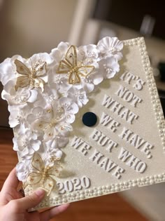 someone holding up a graduation cap with flowers on it