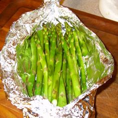 asparagus wrapped in tinfoil on a cutting board