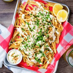 a tray filled with french fries covered in cheese and garnished with parsley