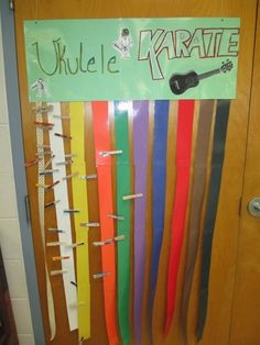 a bulletin board with different colored ribbons hanging on it's sides and the words ukulele karate written on them