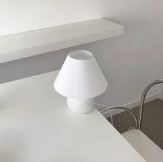 a white lamp sitting on top of a table