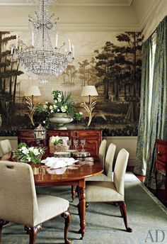 a dining room with a chandelier hanging from the ceiling and paintings on the wall