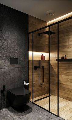 a modern bathroom with black fixtures and wood paneling on the walls, along with a glass enclosed shower stall