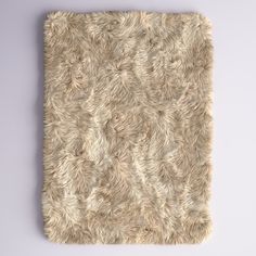 a square area rug made out of sheepskin on a white background with room for text