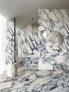 a marble bathroom with two sinks and mirrors