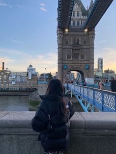 a woman sitting on the edge of a bridge