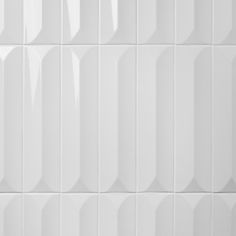 a white tiled wall with vertical lines on it