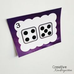 a purple and white card with two dice on it