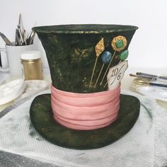 a green top hat sitting on top of a table next to scissors and other items