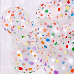 several white balloons with multicolored dots on them