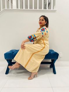 Cream dress with heavy embroidery on sleeves along with neck and tessels and belt. Festive Maxi-length Embroidered Dress, Festive Maxi Embroidered Dress With Embroidered Sleeves, Embroidered Beige Midi Dress, Festive Long Sleeve Dress With Tassels, Festive Long Sleeve Embroidered Midi Dress, Traditional Maxi Dress With Tassels, Multicolor Embroidered Dress With Embroidered Sleeves, Traditional Tassel Maxi Dress, Spring Beige Dress With Embroidered Sleeves