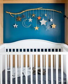 a crib with stars and moon decorations hanging from it