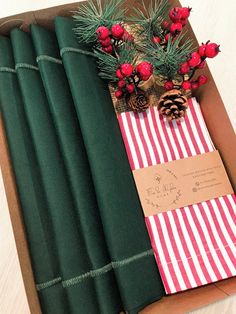 a box filled with green wrapping paper and pine cones