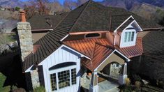 an aerial view of a house with mountains in the background