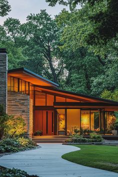 a modern house in the middle of a park with trees and grass on both sides